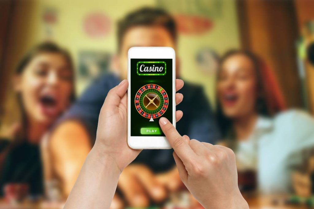 Online gambling - hand holding a mobile phone while playing roulette