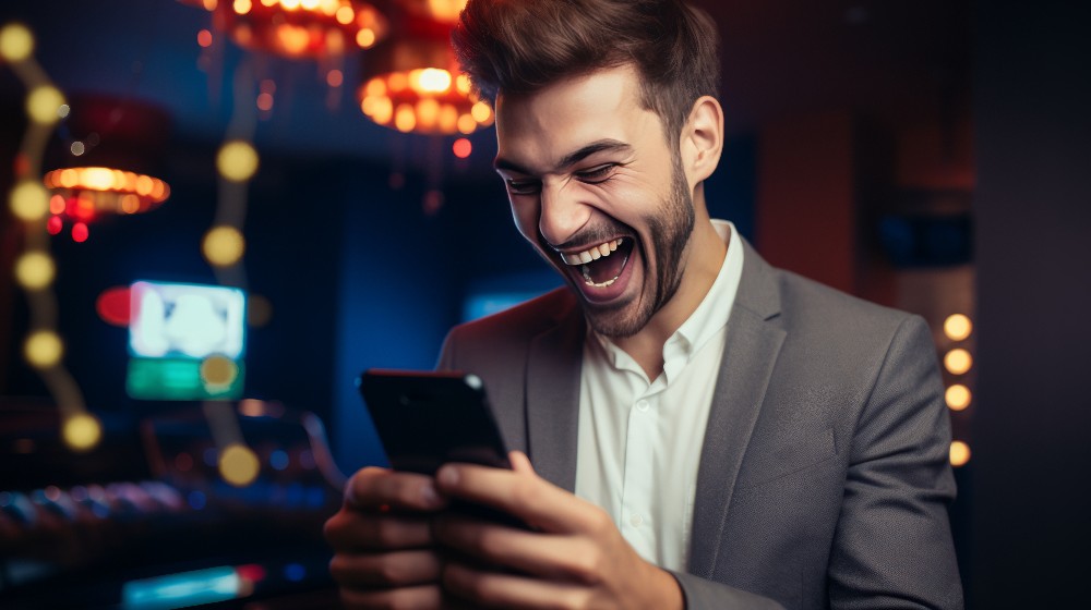 Happy guy playing online casino on his mobile